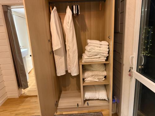 a bathroom with a closet with towels in it at Hills Cottage Holiday Homes in Gränna
