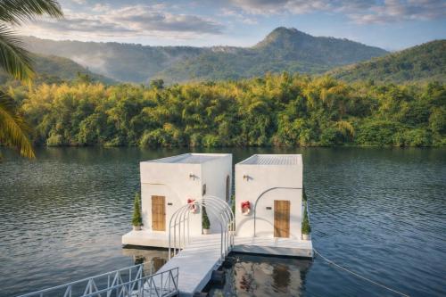 a dock in the middle of a body of water at Heaven Raft Erawan Floating Resort Romantic River View in Ban Mong Lai