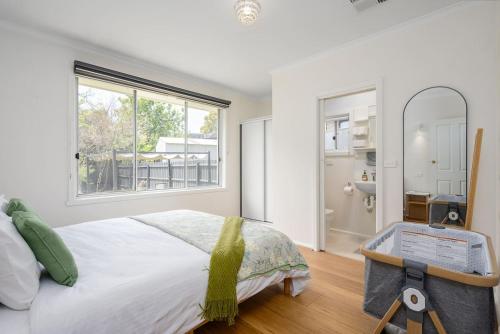 a bedroom with a bed and a large window at Spacious Multifunctional 5BR Retreat with Backyard in Bayswater