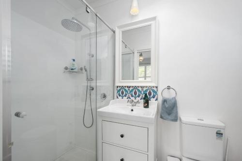 a white bathroom with a shower and a sink at Spacious Multifunctional 5BR Retreat with Backyard in Bayswater