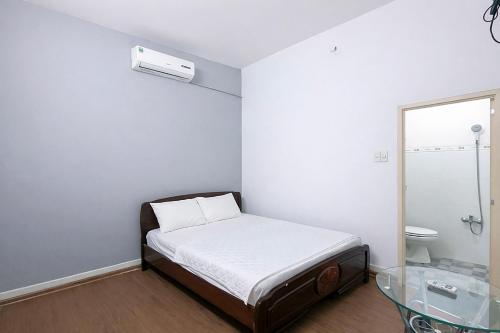 a small room with a bed and a mirror at Nhà Nghỉ Long Nhi in Nhơn Trạch