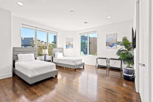 a white living room with two beds and a couch at King-Sized Comfort with Rooftop Skyline Views in Dallas
