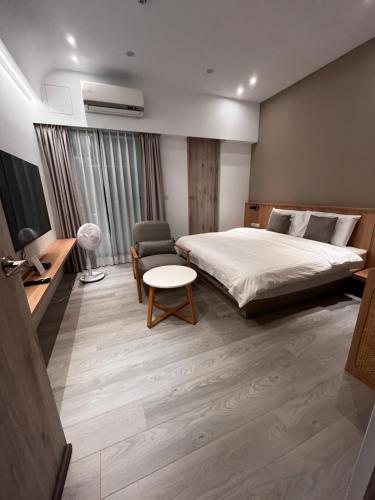 a hotel room with a bed and a chair at Zao Orange Homestay in Taitung City