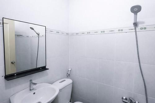 a bathroom with a shower and a sink and a mirror at Nhà Nghỉ Long Nhi in Nhơn Trạch