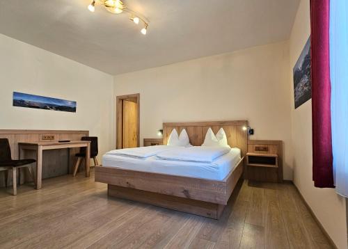 a hotel room with a bed and a desk and a desk at Gasthof-Fleischerei Engl in Kötschach