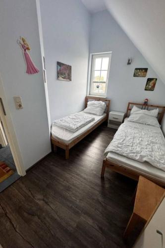 two beds in a small room with a window at Friesenhus in Butjadingen