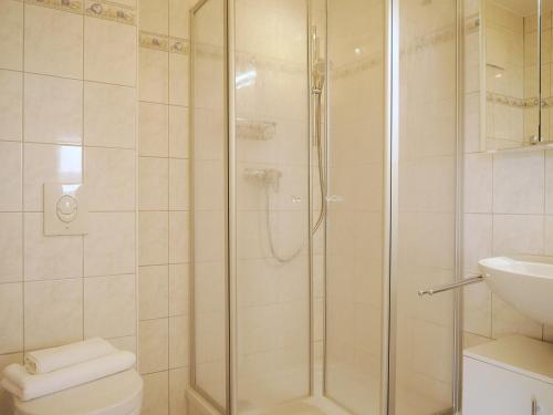 a bathroom with a shower and a toilet and a sink at Seegurke in Am Schwarzen Busch