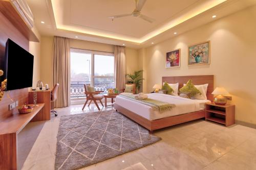 ein Schlafzimmer mit einem großen Bett und einem Fernseher in der Unterkunft Dwellr Luxury Stays - Golf Course Road in Gurgaon