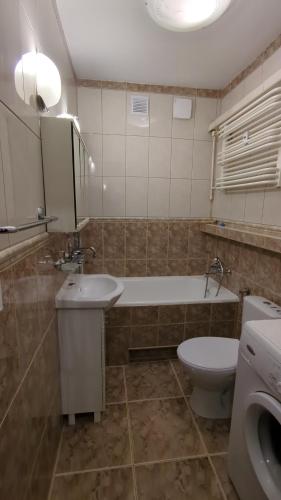 a bathroom with a tub and a toilet and a sink at Apartament Pola in Piła