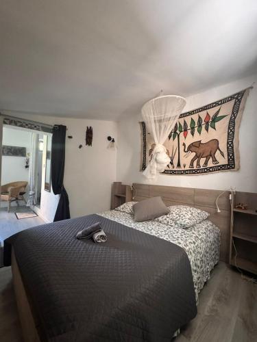 a bedroom with a bed and a picture on the wall at Le Mazet des Beaujots in Monteux