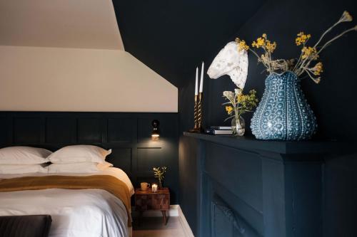 a bedroom with a bed and a blue vase with flowers at The Grandtully Hotel in Grandtully