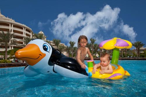 two children playing in the water at a resort at Kempinski Hotel & Residences Palm Jumeirah in Dubai
