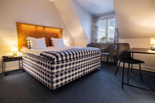 a hotel room with a bed and a desk at Hotell Gillet i Köping in Köping