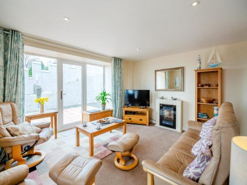 a living room with a couch and a tv at Golygfa Hudol - Uk46712 in Pwllheli