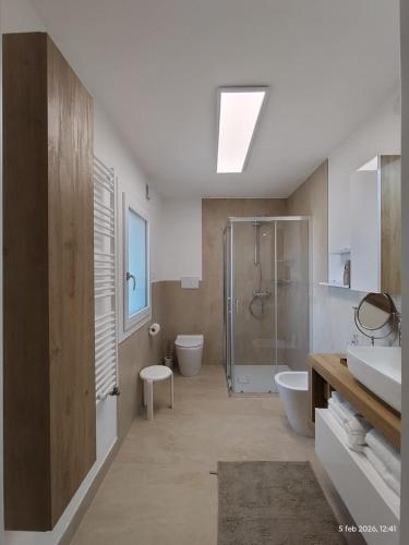 a bathroom with a shower and two toilets and a sink at Turistica Via Po 7 in Legnago