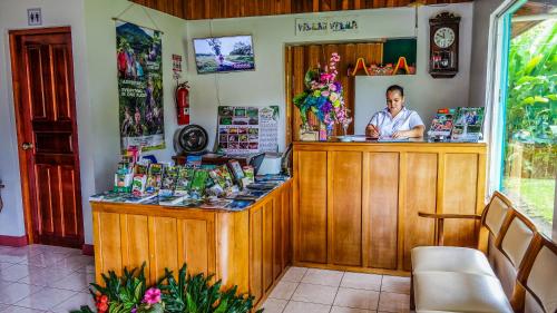 Ein Mann, der an einer Theke in einem Laden sitzt. in der Unterkunft Hotel Villas Vilma in Fortuna