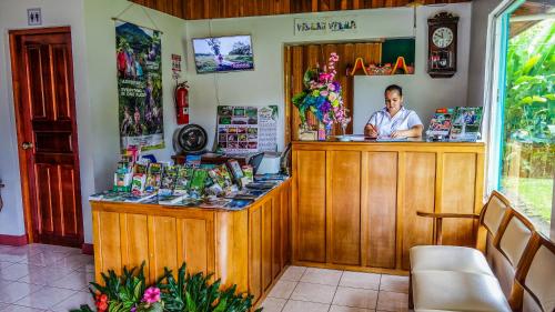 a man sitting at a counter in a shop at Hotel Villas Vilma in Fortuna
