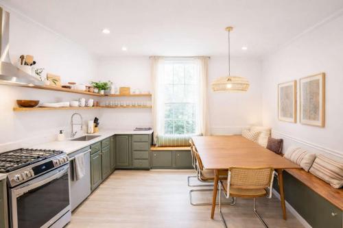 a kitchen with green cabinets and a wooden table at Remodeled Modern Home - private backyard & games! in Louisville