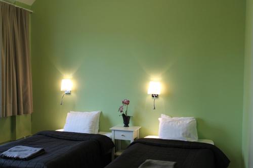 two beds in a room with green walls at Hotel Torslanda in Torslanda