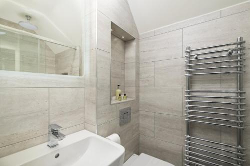 a white bathroom with a sink and a mirror at The Cricket Inn in Kingsbridge
