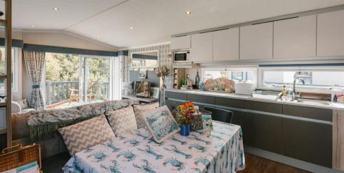 a kitchen and a living room with a couch and a table at Serenity in Saint Erth