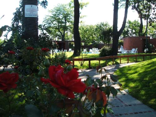 a garden with red flowers and a fence at El Mirador Hotel & Spa in Colonia del Sacramento