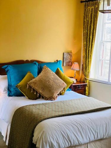 ein Schlafzimmer mit einem Bett mit blauen und grünen Kissen in der Unterkunft Softleys in Market Bosworth