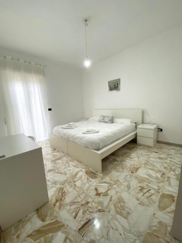a bedroom with a bed and a marble floor at Casa Giulia, comoda palazzina indipendente in Reggio di Calabria
