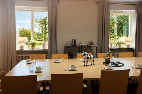 a dining room with a large wooden table and chairs at Hotell Gillet i Köping in Köping