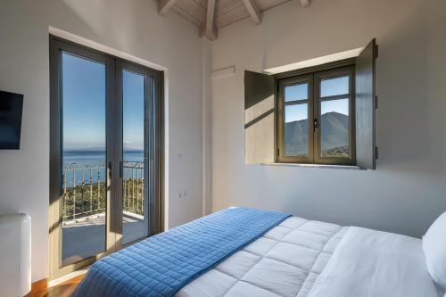 a bedroom with a bed and a large window at Dio Escapes Villas in Poulithra