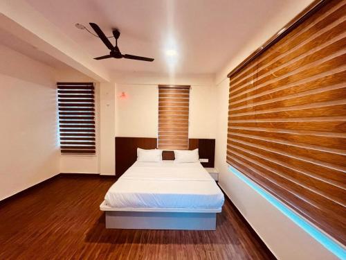 a bedroom with a bed and a ceiling fan at Aetheria Estate Retreat in Chikmagalūr