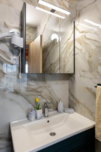 a bathroom with a white sink and a mirror at Vikendice Kutlešić in Čajetina