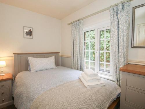 a bedroom with a bed and a window at 2 Aqueduct Cottages in Wrexham