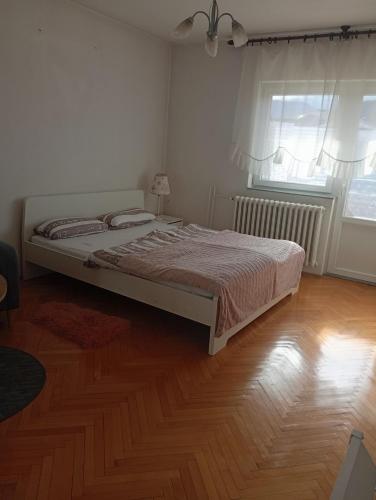 a bedroom with a bed and a wooden floor at Kleopa in Pale