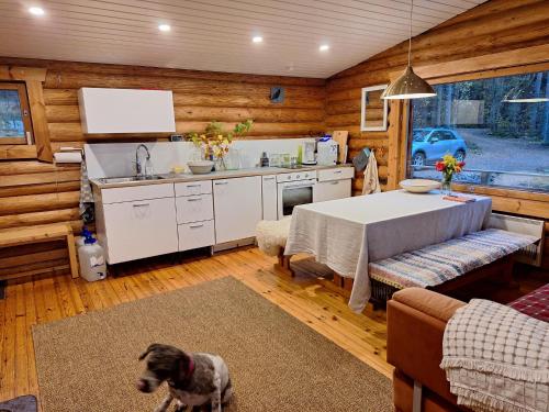 a kitchen with a table and a dog in a room at Beautiful Cottage at Lake Saimaa, Rantamaja in Juva