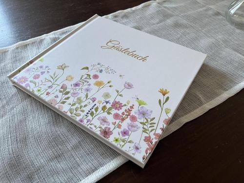 a book with flowers on it sitting on a table at Ferienwohnung "Am Malerweg" Lohmen in Lohmen