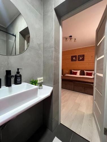 a bathroom with a sink and a bed in the background at MiS Family house з чаном та сауною in Kosiv