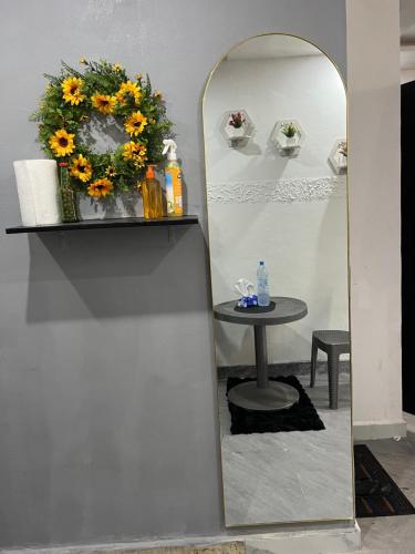 uno specchio su una parete con un tavolo e dei fiori di Beni'o Suite a Adiapo-Doumé