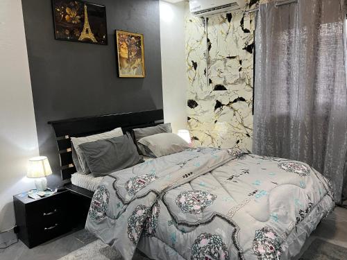 una camera da letto con un letto e un muro di pietra di Beni'o Suite a Adiapo-Doumé