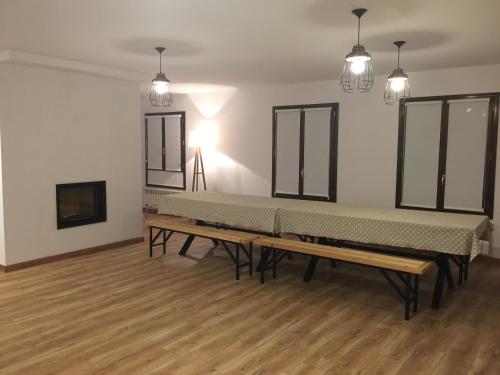 a row of benches in a room with wooden floors at Casa Campo in Abay