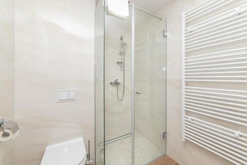 a white bathroom with a glass shower stall at Inamore in Gradac