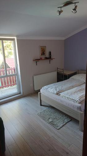 a bedroom with a bed and a large window at Tyrolczyk in Szklarska Poręba