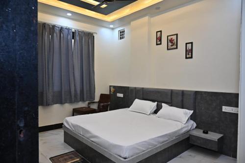 a bedroom with a large bed with white sheets at Hotel Radhe in Bhind