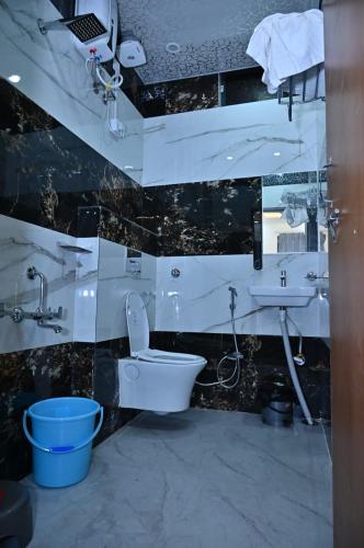 a bathroom with a toilet and a sink at Hotel Radhe in Bhind