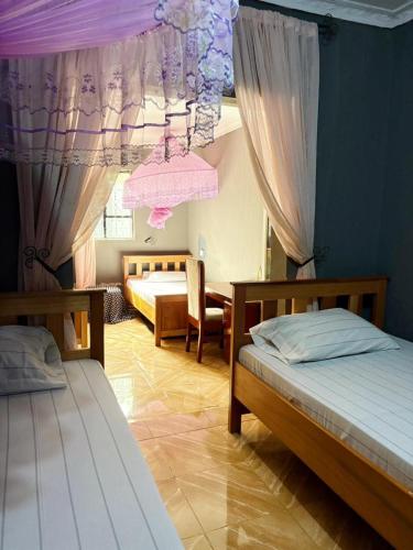 a bedroom with two beds and a room with at Esther Villas Home in Boma la Ngombe