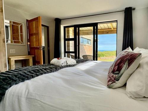 a large white bed with a view of the ocean at Sea La Mer Villa in Wilderness