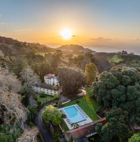an aerial view of a house with a pool and trees at Casa Velha do Palheiro Relais & Chateaux in Funchal