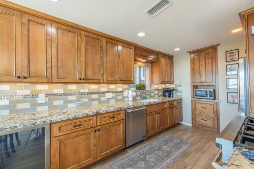 a kitchen with wooden cabinets and stainless steel appliances at Beach Bum Retreat in Cayucos