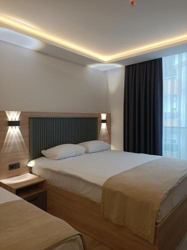 a hotel room with two beds and a window at Döşemealtı Konfor Hotel in Dosemealti