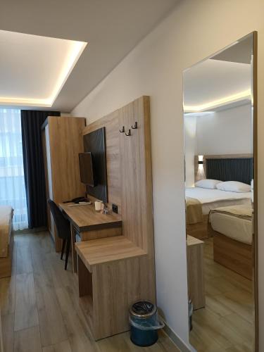 a hotel room with a desk and a bed at Döşemealtı Konfor Hotel in Dosemealti